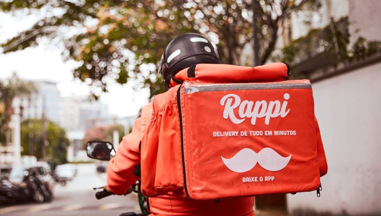 Entregador da Rappi recebendo pedidos em um restaurante.