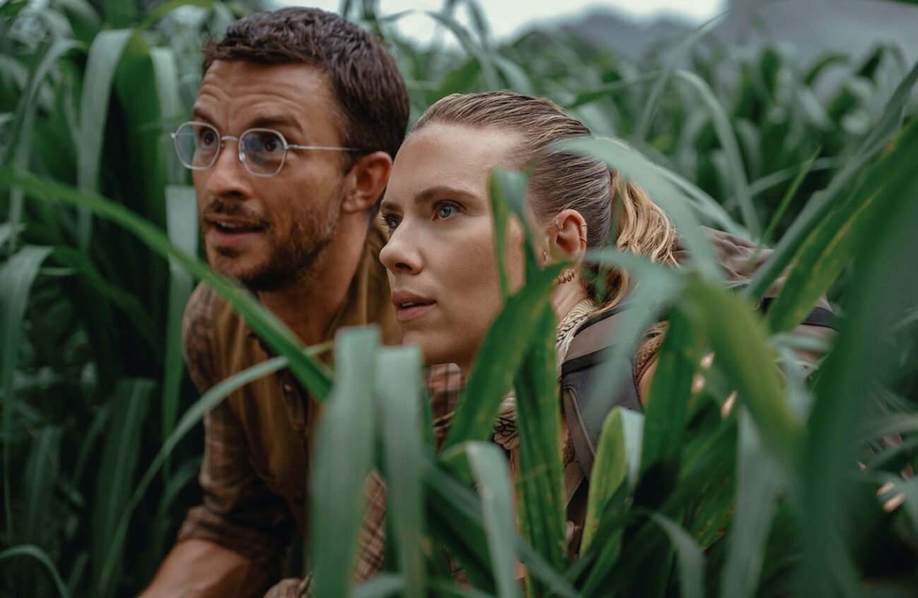Scarlett Johansson como Zora Bennett em "Jurassic World Rebirth", enfrentando um dinossauro em uma selva tropical.